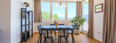 a dining room with a blue table and chairs at Haus Pobitzer in Caldaro