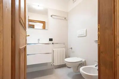 a white bathroom with a sink and a toilet at Appartamento 4 posti letto in Borca di Cadore
