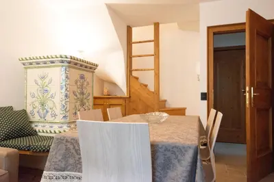 a dining room with a table and a chair at Appartamento 4 posti letto in Borca di Cadore