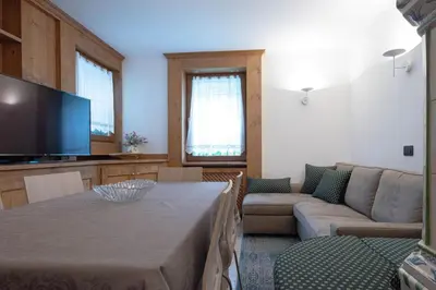 a living room with a table and a couch at Appartamento 4 posti letto in Borca di Cadore