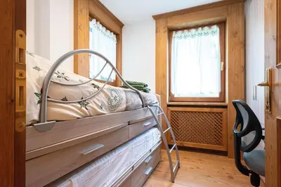 a bedroom with a bed with a metal frame at Appartamento 4 posti letto in Borca di Cadore