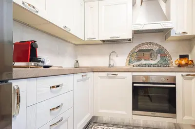 a kitchen with white cabinets and a sink at Appartamento 4 posti letto in Borca di Cadore