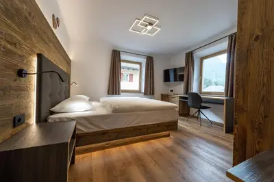 a bedroom with a bed and a desk with a computer at Apartment Fina in Ortisei
