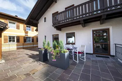 a patio with a table and chairs and a building at Apartment Fina in Ortisei