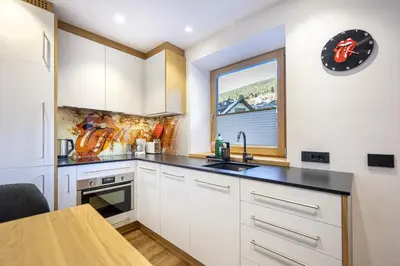 a kitchen with white cabinets and a window at Apartment Fina in Ortisei
