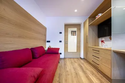 a living room with a red couch and a kitchen at Apartment Fina in Ortisei