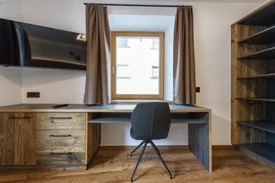 a desk with a chair in a room with a window at Apartment Fina in Ortisei