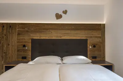 a bedroom with a large bed with two pillows at Apartment Fina in Ortisei