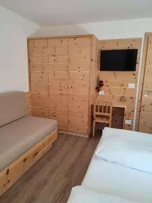 a bedroom with two beds and a flat screen tv at Apartments B&B Pretermo in Badia