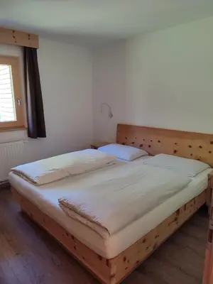 a bed in a room with a wooden headboard at Apartments B&B Pretermo in Badia