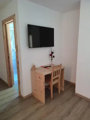 a room with a desk and a television on a wall at Apartments B&B Pretermo in Badia