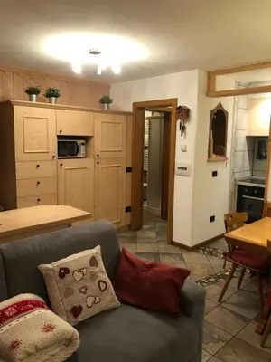 a living room with a couch and a kitchen at Casa Gallo in Mazzin