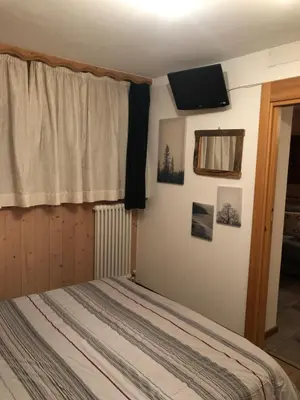 a bedroom with a bed and a television on the wall at Casa Gallo in Mazzin