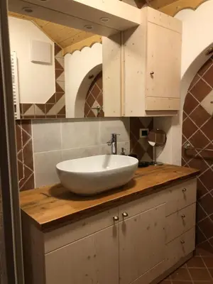 a bathroom with a white sink on a wooden counter at Casa Gallo in Mazzin