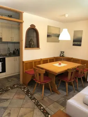 a kitchen and dining room with a wooden table and chairs at Casa Gallo in Mazzin
