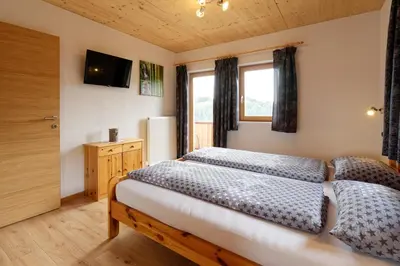 a bedroom with two beds and a window at Kehrerhof Urlaub auf dem Bauernhof in San Lorenzo di Sebato