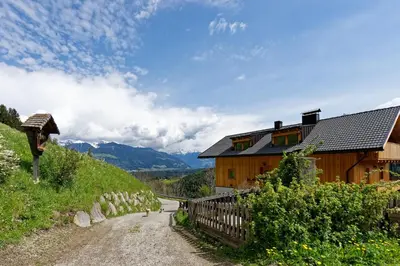a house on a hill next to a dirt road at Kehrerhof Urlaub auf dem Bauernhof in San Lorenzo di Sebato