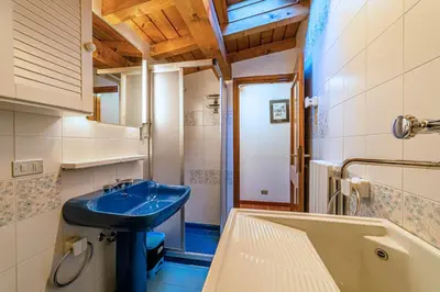 a bathroom with a blue sink and a tub at Tizzi Home in Alleghe