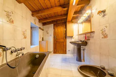 a bathroom with a large tub and a sink at Tizzi Home in Alleghe