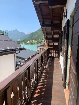 a balcony of a house with a view of a lake at Tizzi Home in Alleghe