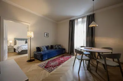 a living room with a blue couch and a table at Hotel Bruneck Design-Suites in Brunico