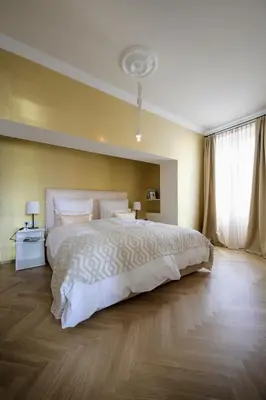 a bedroom with a large white bed and a window at Hotel Bruneck Design-Suites in Brunico