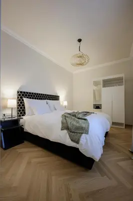 a bedroom with a large bed with white sheets at Hotel Bruneck Design-Suites in Brunico