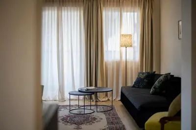a living room with a couch and a table in front of a window at Hotel Bruneck Design-Suites in Brunico
