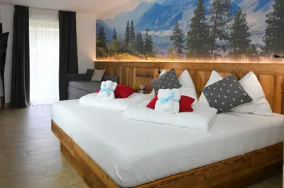 a bedroom with a large white bed with pillows at Mas dei Masi in Cavalese