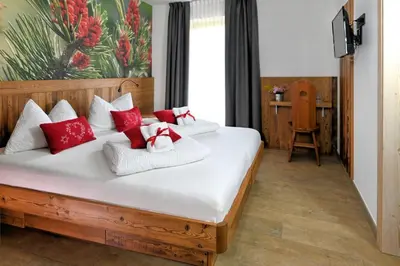 a bedroom with a bed with red and white pillows at Mas dei Masi in Cavalese