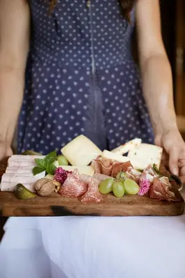 a person holding a plate of cheese and meats at Nössinghof in Tirolo