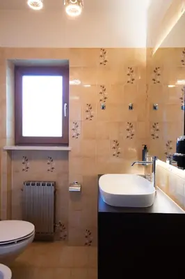 a bathroom with a sink and a toilet and a window at Nössinghof in Tirolo