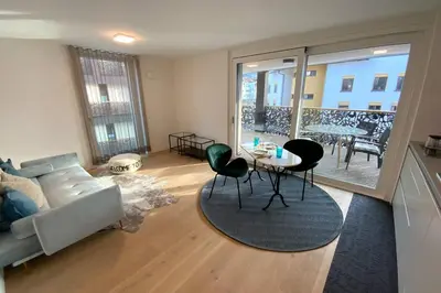 a living room with a couch and a table and chairs at Riversuite in Bressanone