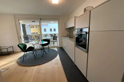 a kitchen with a table and chairs in a room at Riversuite in Bressanone