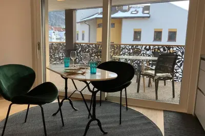 a table and chairs in a room with a balcony at Riversuite in Bressanone