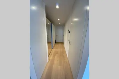 a hallway with white walls and a wooden floor at Riversuite in Bressanone