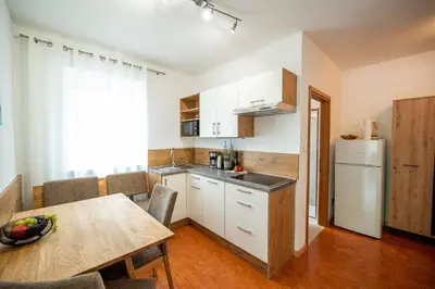 a kitchen with a table and a white refrigerator at Ferienwohnung am Kalterer See in Südtirol in Caldaro