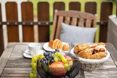 a table with baskets of fruit and bread on it at Ferienwohnung am Kalterer See in Südtirol in Caldaro