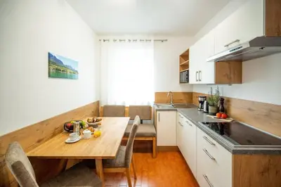 a kitchen with a wooden table and a dining room at Ferienwohnung am Kalterer See in Südtirol in Caldaro