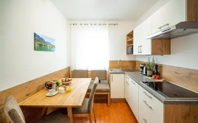 a kitchen with a wooden table and a dining room at Ferienwohnung am Kalterer See in Südtirol in Caldaro