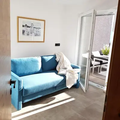 a blue couch in a living room with a mirror at Rooftop-Schenna in Schenna