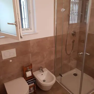 a bathroom with a shower and a toilet and a sink at Rooftop-Schenna in Schenna