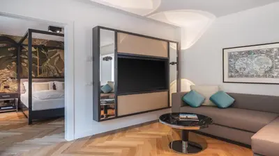 a living room with a couch and a tv at Palm Loggias Meran in Merano