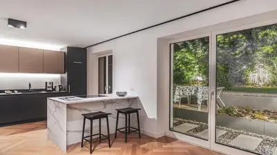 a kitchen with a counter and stools in a room at Palm Loggias Meran in Merano