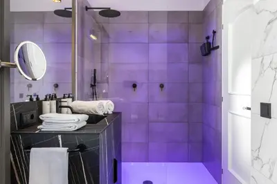 a purple bathroom with a shower with a mirror at Palm Loggias Meran in Merano