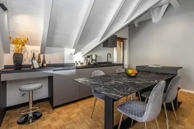 a kitchen with a marble table and chairs at Palm Loggias Meran in Merano