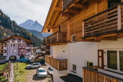 a view from the balcony of a building with cars parked at Appartamenti Cèsa Sorèie by AMA Val di Fassa in Canazei