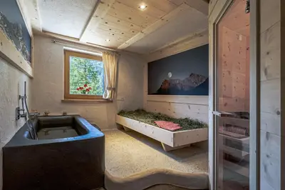 a bathroom with a large tub and a window at Ciasa Iachin - Dolomites Dream Retreat in San Martino in Badia