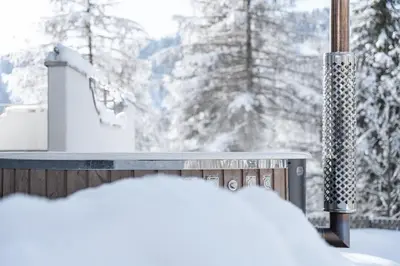 a snow covered window with a view of snow covered trees at Ciasa Iachin - Dolomites Dream Retreat in San Martino in Badia