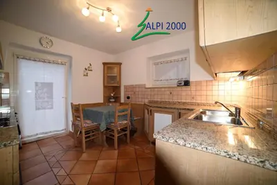 a kitchen with a sink and a table in it at Casa Dolomiti - BERTA in Campitello di Fassa